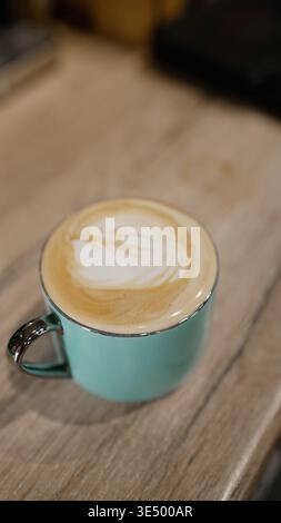 Latte art in a turquoise coffee mug Stock Photo