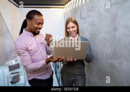 Team collaboration and digital transformation with colleagues sharing ideas at a laptop in office Stock Photo