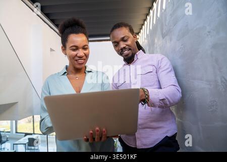 Team collaboration and digital transformation with colleagues sharing ideas at a laptop in office Stock Photo
