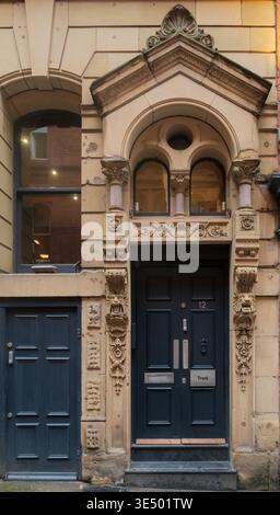 An ornate Victorian carved stone doorcase at 12 Tib Lane, Manchester, with decorative pilasters, lions and acanthus leaf carving. Stock Photo