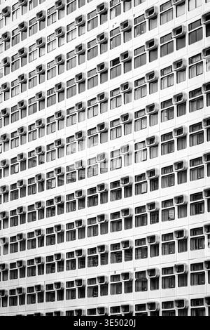 The repeating rounded window surrounds of the Premier Inn City Heights hotel, Salford, Manchester, in black and white. Stock Photo