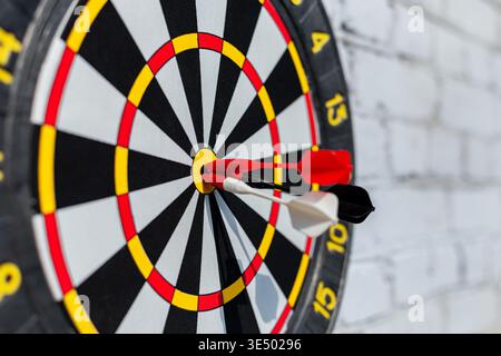 Three darts hit the center of the target. Successful marketing and advertising, concept. Close up shot red darts arrows in the target of dartboard cen Stock Photo