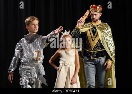 Dynamic tutor guides kids in an engaging theater lesson with costumes and imaginative play. Stock Photo
