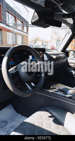 Driving a modern car interior on a busy street during daylight Stock Photo