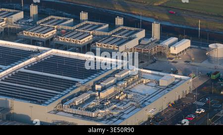 Aerial view of the Google Data Center Winschoten featuring cooling units, rooftop solar panels, and a parking lot in Winschoten, Netherlands. Stock Photo