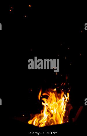 The fire burns at night. Fire and sparks on a black background Stock Photo
