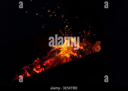 beautiful fire burns with sparks in the night. Bonfire on a black background Stock Photo