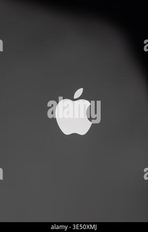 Vinkovci, Croatia -  November 19.2025: A clean Apple logo sits against a moody black to gray gradient, offering high contrast and a modern feel. Ideal Stock Photo