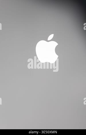 Vinkovci, Croatia -  November 19.2025: A clean Apple logo sits against a moody black to gray gradient, offering high contrast and a modern feel. Ideal Stock Photo