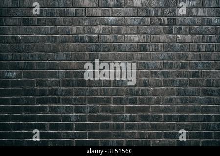 Texture of a perfectly laid dark charcoal-black brick wall as background Stock Photo