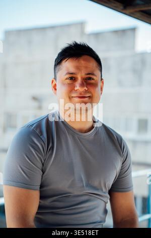 Portrait of smiling slavic man brunette wearing casual gray t shirt outdoors with soft background modern lifestyle and natural light. Stock Photo