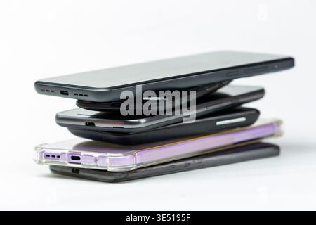 A stack of used smartphones, often referred to as e-waste or items ready for recycling Stock Photo