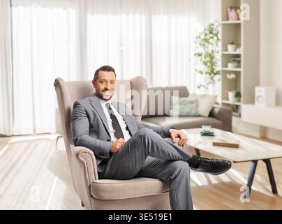 Confident businessman sitting in an armchair at home Stock Photo