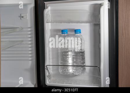 two bottles of still water in empty fridge, indoor shot , no people Stock Photo