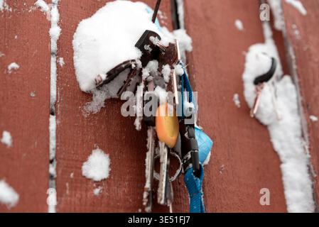 a bunch of door keys hanging on the wall covered with snow, outdoor closeup Stock Photo
