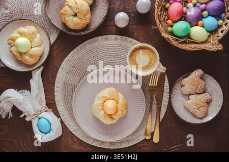 Easter wreaths made from yeast dough for Easter brunch with colored eggs and pastries. Stock Photo
