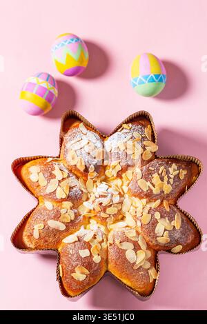 Easter Flower Shaped Cake with Almonds and Painted Eggs on Pink Background Stock Photo