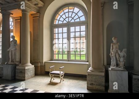 A chair sits in front of an arched window with a view of the Logårdengarden of the Royal Palace, from inside the hall of antiquities, Stockholm Sweden Stock Photo