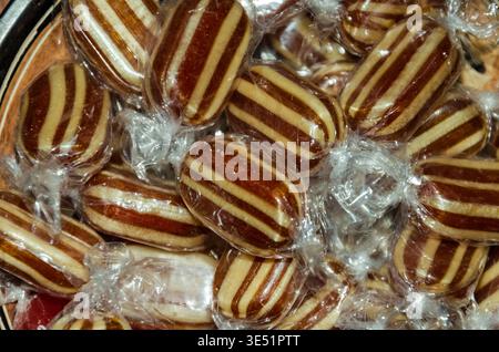 Close-up of mint humbugs with brown stripes wrapped in cellophane useful as a background for an advertisement Stock Photo