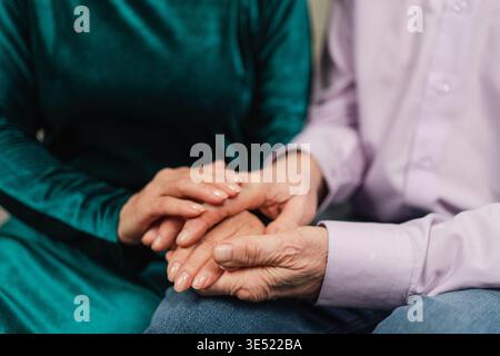 Old couple hands. Senior couple in love holding hands. Mid age old husband wife touching hands with tenderness love enjoying wellbeing. Grandmother grandfather together. Family moment love and care Stock Photo