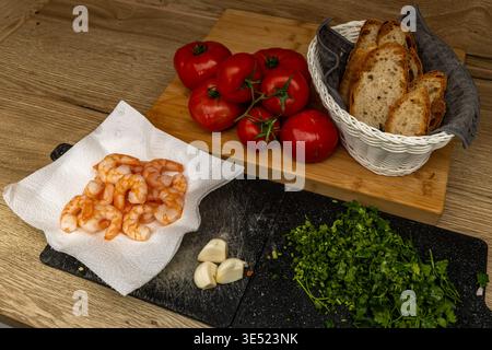 Creative collage composition featuring layered printed pages, a red tomato, white yarn, and textured fabric on a wooden table. The image blends everyd Stock Photo