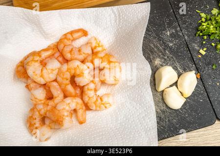 Creative collage composition featuring layered printed pages, a red tomato, white yarn, and textured fabric on a wooden table. The image blends everyd Stock Photo