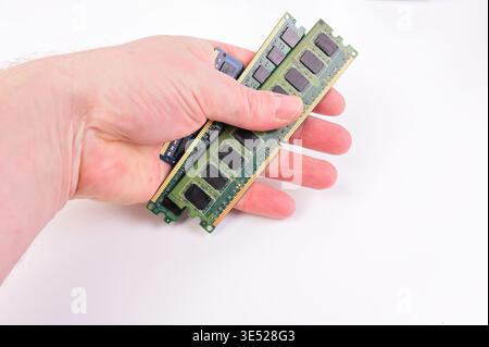 Hand holding multiple computer RAM modules on a white background Stock Photo
