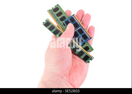 Hand holding multiple computer RAM modules for upgrade or repair Stock Photo