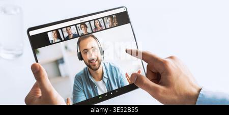 Businessman Using Tablet to Connect With Colleagues During Virtual Meeting in Office Setting Stock Photo