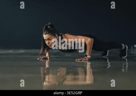 Strong woman doing push ups exercises indoors Stock Photo