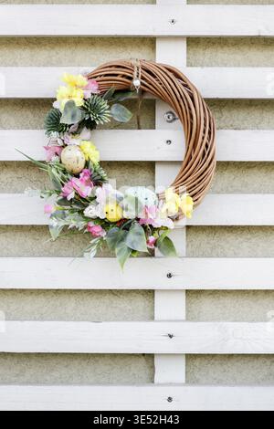 A charming Easter wreath for the door or wall, handmade with flowers, eggs and feathers. Festive decor Stock Photo