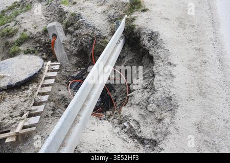 A large and dangerous hole, a landslide on the side of the asphalt road. Graphic resources Stock Photo