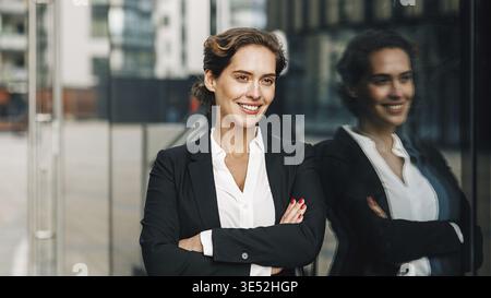 Young entrepreneur at office building. Confident woman standing outdoors and looking away Stock Photo