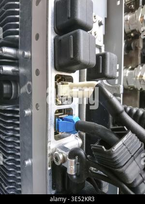 Close-up shot of the back panel of a communication device featuring connectors and cables. Perfect for tech, infrastructure, or connectivity themes Stock Photo