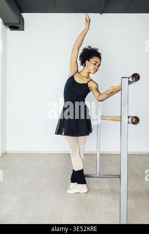 Young artist practicing ballet moves in the studio at barre Stock Photo