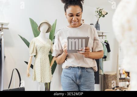 Local clothing store owner standing with digital tablet Stock Photo
