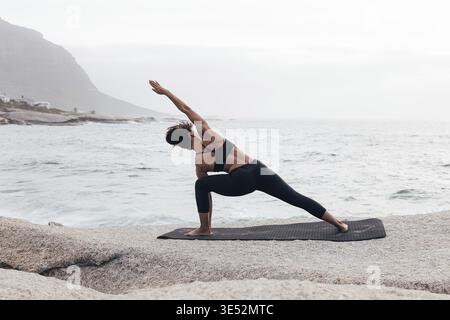 Back view of full length of a woman practicing Utthita Parsvakonasana Stock Photo