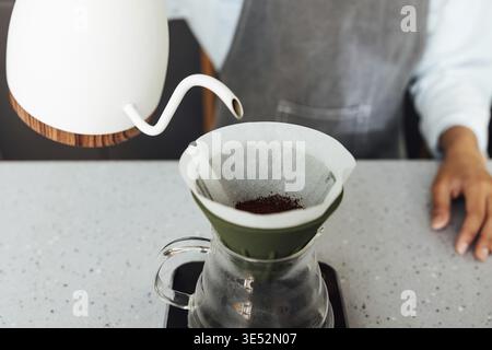 Close-up of an unrecognizable barista brewing coffee with a filter. Process of a gravity-based method of brewing coffee Stock Photo