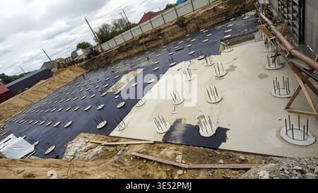 A wide-angle shot captures a construction site foundation, with rebar and concrete work in progress Stock Photo