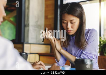 Two colleagues discussing in cafe, sitting at table Stock Photo