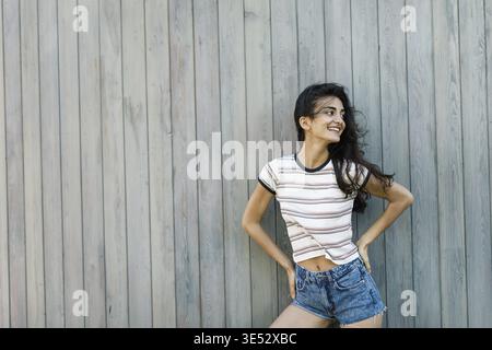 Young happy brunette posing at wall, outdoors shot Stock Photo