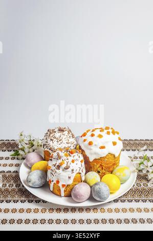 A delightful spread of decorated Easter bread and colorful eggs sits on a beautifully embroidered cloth, evoking spring celebration and culinary tradi Stock Photo