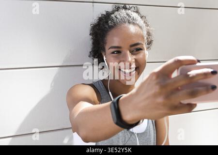 Woman taking selfie after exercising outdoors Stock Photo