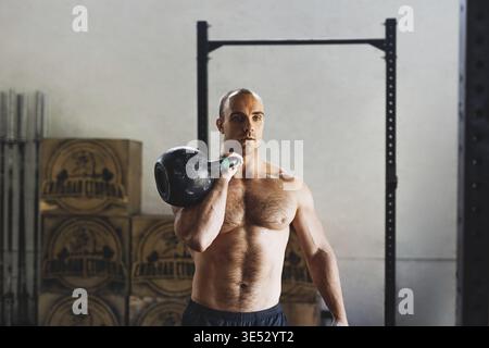 Fitness man doing exercises with kettlebell in gym Stock Photo