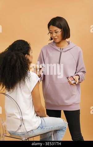 Young make up artist working with model in studio Stock Photo