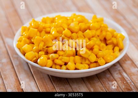 Sweet canned corn in bowl on table Stock Photo