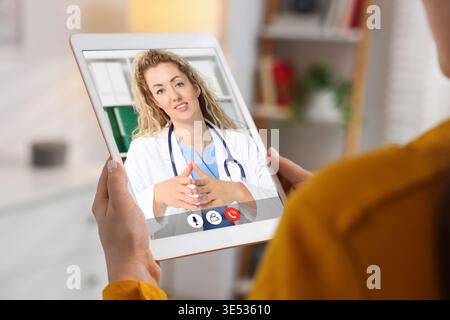 Telemedicine. Woman having online consultation with doctor via tablet computer at home, closeup Stock Photo