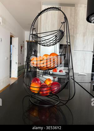 fruit in tiered basket on counter, concept of grocery, home decor, food blog, banner Stock Photo