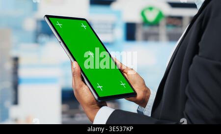 Business professional using isolated screen tablet app to analyze performance dashboards metrics. Woman evaluating annual report data KPIs using mockup digital device, camera B Stock Photo
