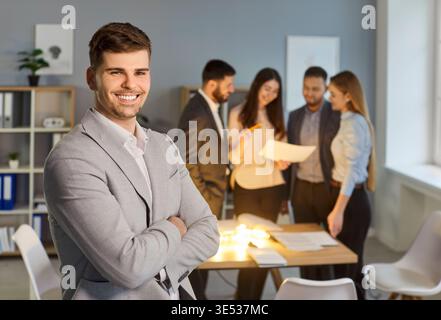 Portrait of skilled businessman office worker dressed in formal suit, standing in office Stock Photo